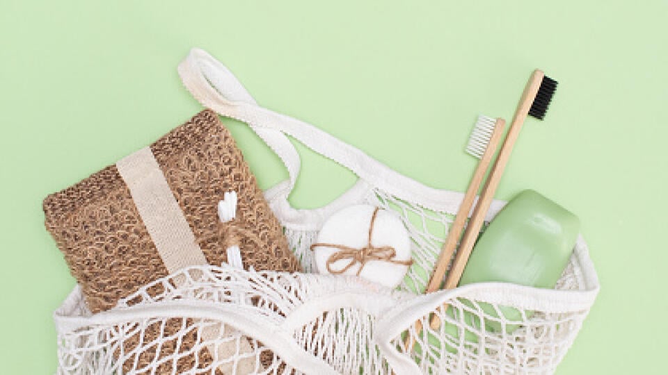 eco-friendly bamboo teethbrush on a light green background