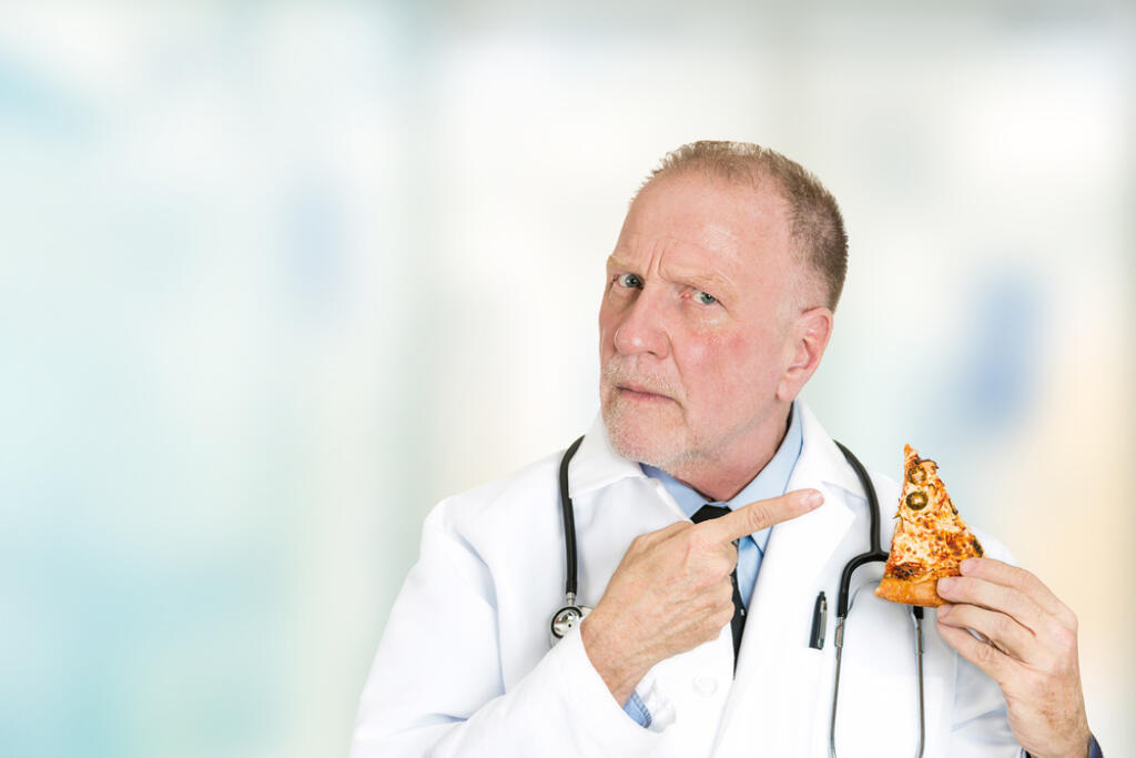 Senior,Serious,Doctor,Advises,Against,Fatty,Food,Pointing,At,Slice