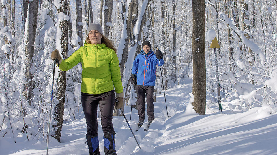 A couple cross country skis in fresh snow in canada