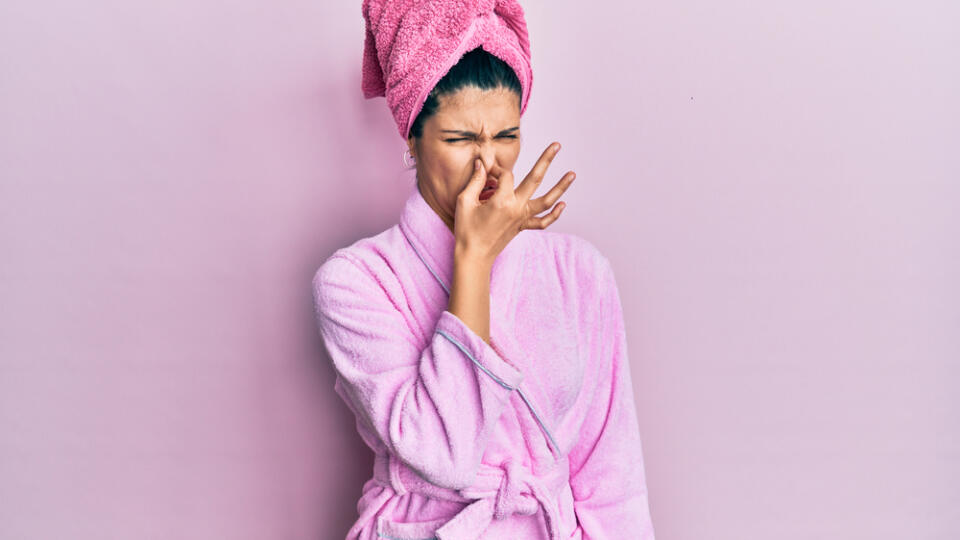 Young,Hispanic,Woman,Wearing,Shower,Towel,Cap,And,Bathrobe,Smelling