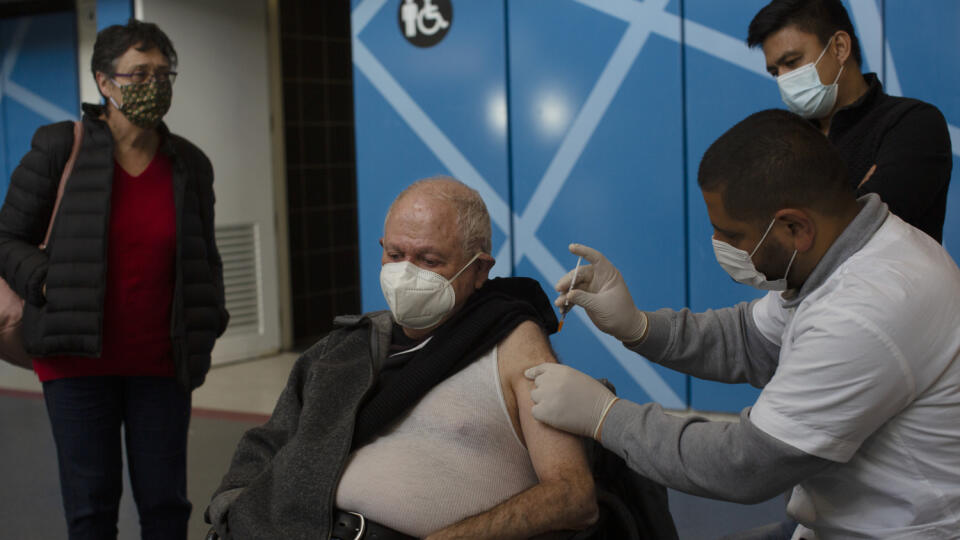 KK33 Jeruzalem - Na snímke muž počas očkovania vakcínou proti ochoreniu Covid-19 od spoločnosti Pfizer vo vakcinačnom centre 14. januára 2021 v Jeruzaleme. FOTO TASR/AP
A medical professional administers the Pfizer COVID-19 vaccine to a man under the watchful eyes of his wife and home health care aide, who also got the vaccine, at a makeshift vaccination center in a sports arena in Jerusalem, Thursday, Jan. 14, 2021 . (AP Photo/Maya Alleruzzo)