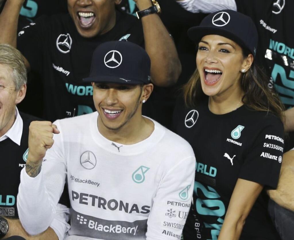 Mercedes driver Lewis Hamilton of Britain celebrates with his partner American singer Nicole Scherzinger after winning the Emirates Formula One Grand Prix to clinch the Formula One world championship at the Yas Marina racetrack in Abu Dhabi, United Arab Emirates, Sunday, Nov. 23, 2014. (AP Photo/Kamran Jebreili)