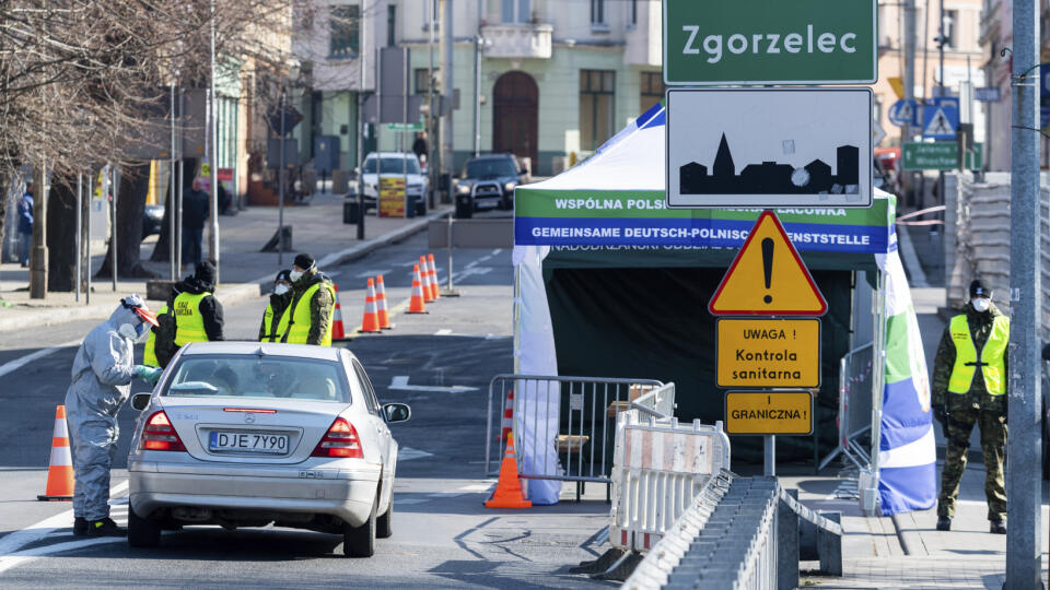 Muž v ochrannom obleku meria teplotu vodičom na Moste priateľstva na poľskej hranici s Nemeckom Zgorzelec, v nemeckom pohraničnom meste Görlitz.