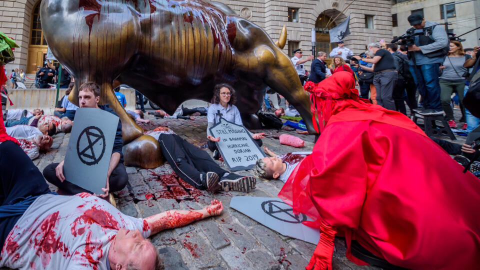 Activists covered the Wall Street Bull in blood and perform