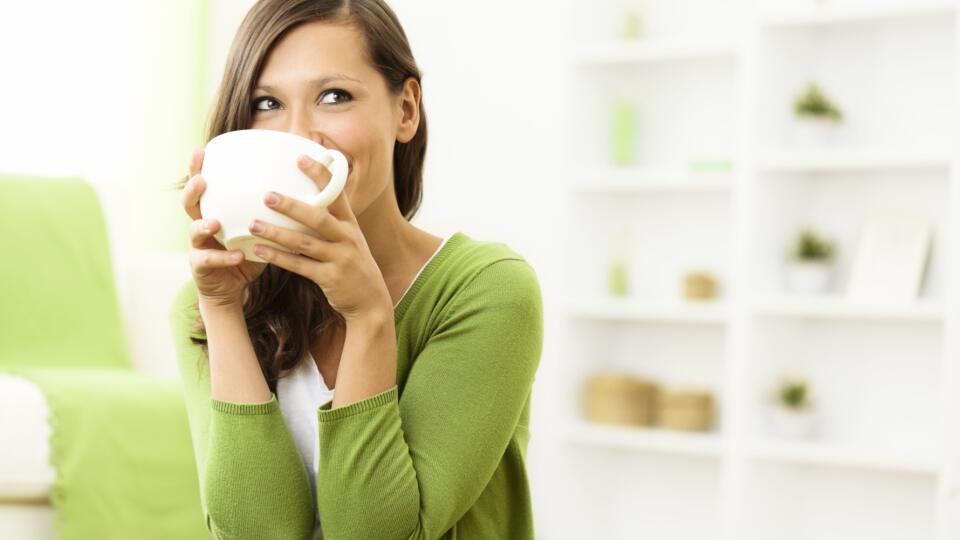 Beautiful woman enjoying a cup of coffee at home