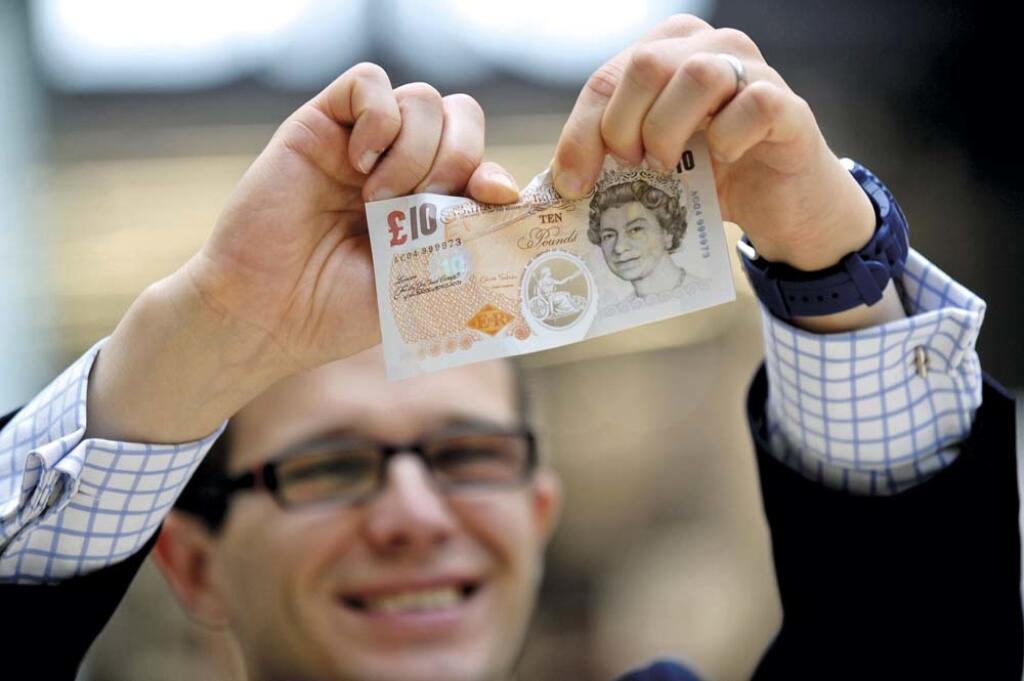 Prototype polymer banknotes being shown to members of the public by the Bank of England as part of their public consultation programme before deciding whether to print its next banknotes on polymer, The Grafton Centre, Cambridge, UK.  25/09/2013.  Pictured is a man attempting to tear one of the polymer banknotes.