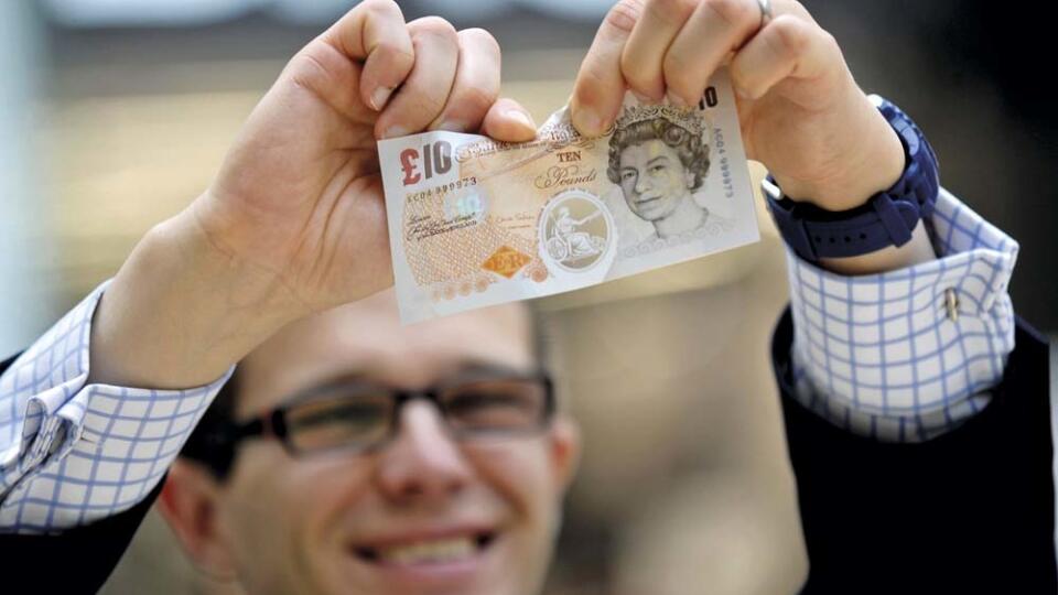 Prototype polymer banknotes being shown to members of the public by the Bank of England as part of their public consultation programme before deciding whether to print its next banknotes on polymer, The Grafton Centre, Cambridge, UK. 25/09/2013. Pictured is a man attempting to tear one of the polymer banknotes.