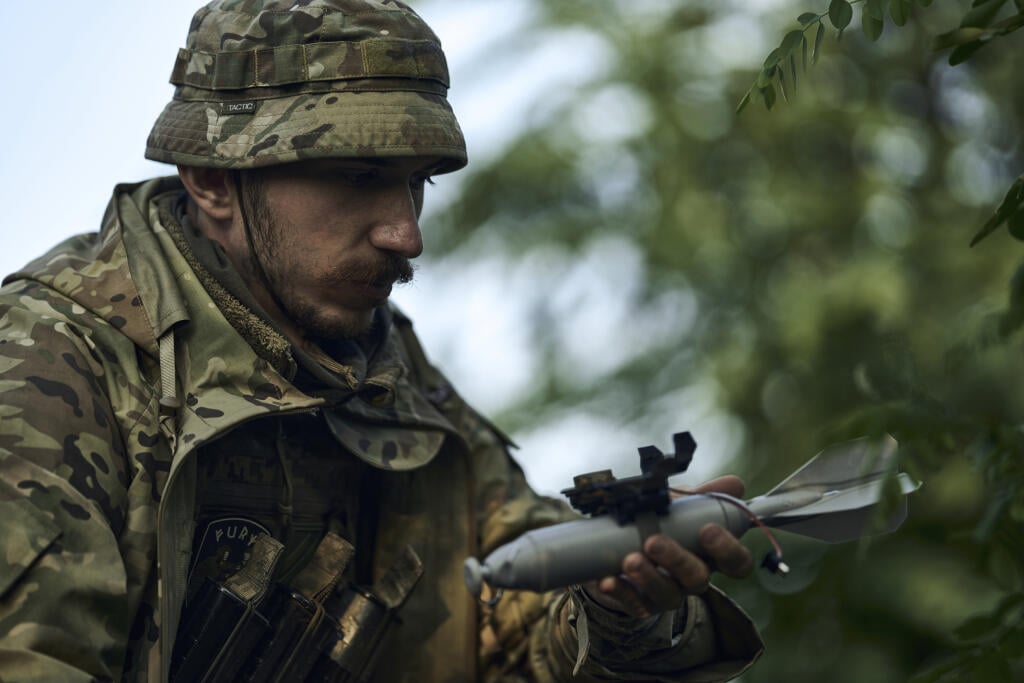 Vojak 3. ukrajinskej samostatnej útočnej brigády pripevňuje bombu na dron
