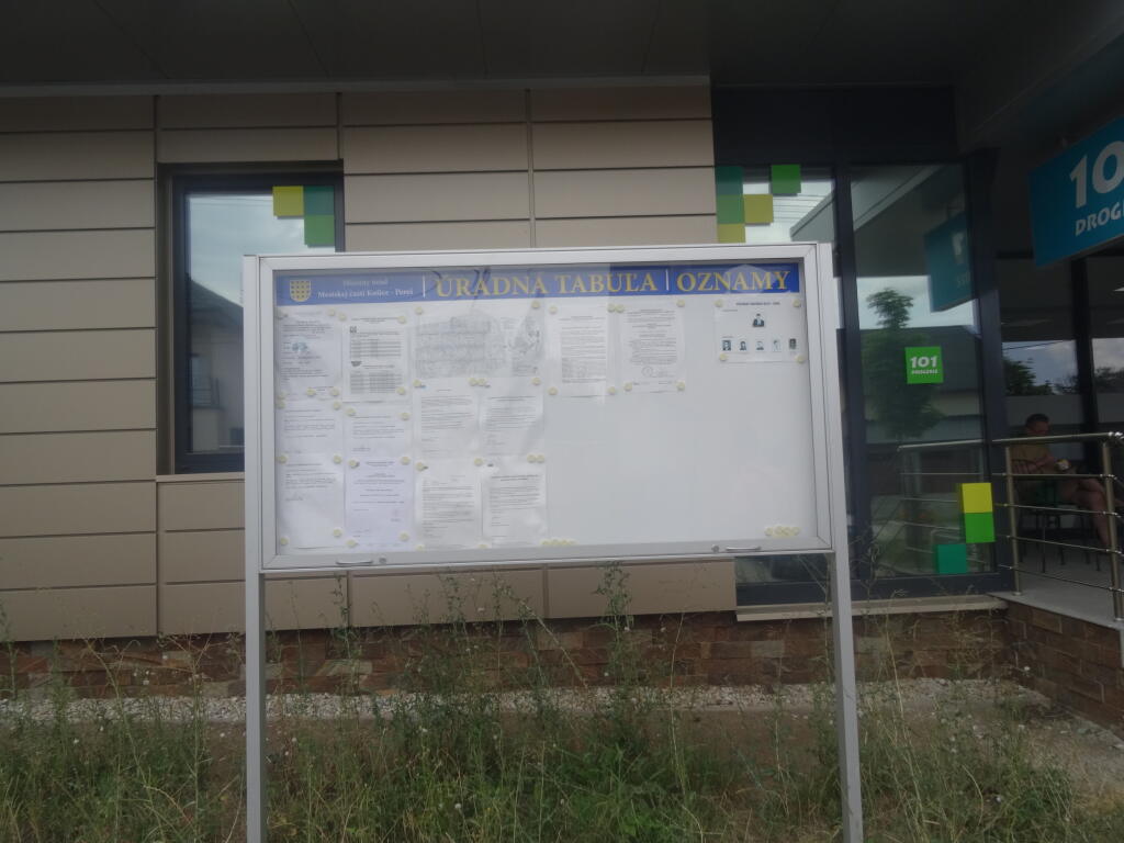 Verejná tabuľa pred MÚ MČ Košice Pereš, kde visí oznam o zrušení trvalého pobytu Nory Kabrheľovej.