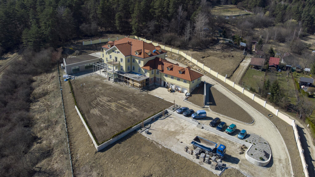 Provizórne parkovisko je plné áut, čo prezrádza, že robotníci naďalej makajú na prerábke honosného sídla Petra Sagana.