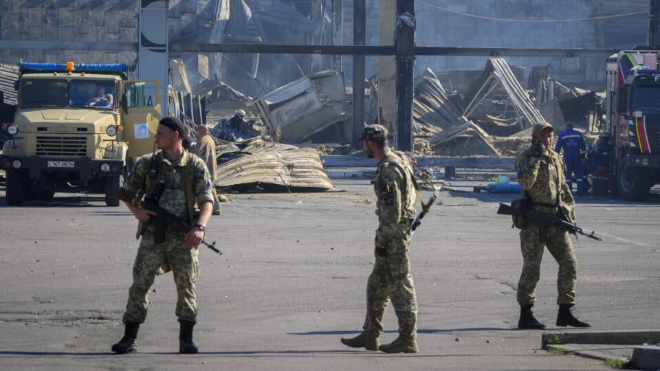 JB 20 Kremenčuk - Ukrajinskí vojaci stoja pred budovou nákupného centra po ruskom raketovom útoku v ukrajinskom meste Kremenčuk 28. júna 2022. Ukrajinský prezident Volodymyr Zelenskyj označil pondelkový raketový útok Ruska na nákupné centrum v ukrajinskom meste Kremenčuk za