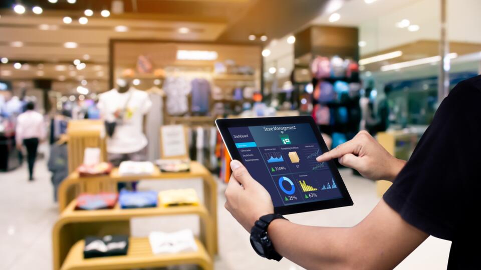 Smart store management systems concept.Manager using digital tablet on blurred store as background