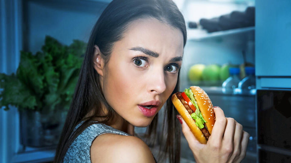Young,Woman,Eating,Burger,From,Fridge,At,Night,Kitchen.,Diet