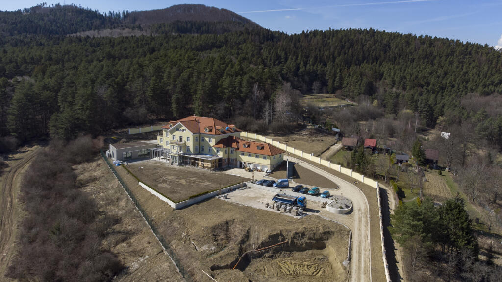 Provizórne parkovisko je plné áut, čo prezrádza, že robotníci naďalej makajú na prerábke honosného sídla Petra Sagana.