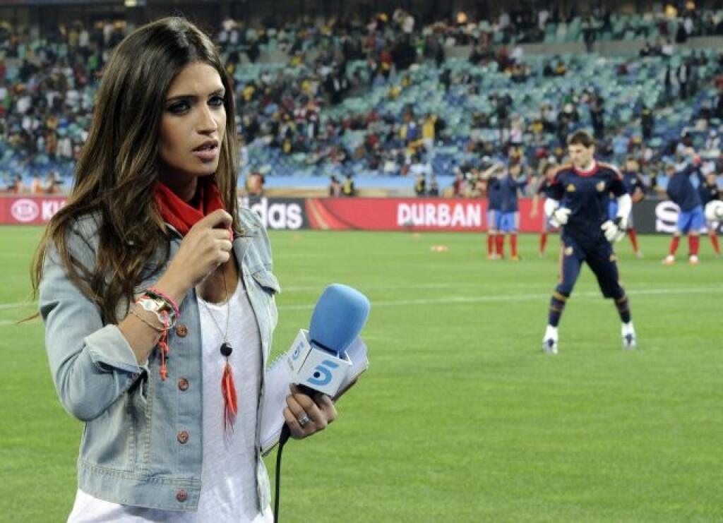 Spanish sport TV journalist presenter Sara Carbonero, left, works as her boyfriend Spain goalkeeper Iker Casillas, right, warms up, prior to the World Cup semifinal soccer match between Germany and Spain at the stadium in Durban, South Africa, Wednesday, July 7, 2010. (AP Photo/Martin Meissner)