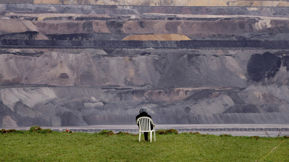 KK37 Erkelenz - Na snímke osoba sedí na stoličke vedľa hnedouhoľnej bane v dedine Lützerath v Nemecku 10. januára 2023. Niekoľko stoviek klimatických aktivistov sa v utorok snažilo zablokovať vstup ťažkých mechanizmov do vysídlenej dediny Lützerath v Nemecku, ktorá má byť zrovnaná so zemou z dôvodu rozšírenia hnedouhoľnej bane. Baňa, kde sa ťaží hnedé uhlie spaľované v neďalekých elektrárňach, sa má podľa dohody, ktorú vlani uzavrela vláda spolkovej krajiny Severné Porýnie-Vestfálsko a energeti