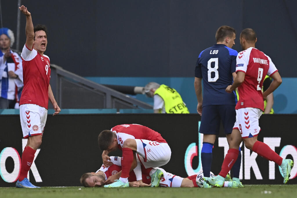 Dánsky futbalista Christian Eriksen leží nehybne na trávniku počas zápasu základnej B-skupiny Dánsko - Fínsko na európskom šampionáte v Kodani v sobotu 12. júna 2021.