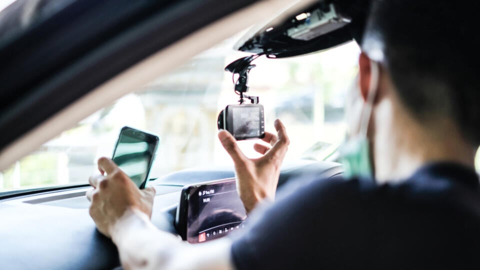 Close,Up,Technician,Hand,With,Car,Camera,And,Smartphone,Inside