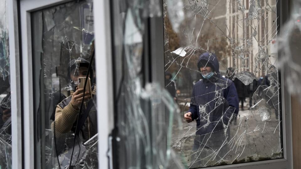 KK14 Alma-Ata - Muž si fotí rozbité okno počas protestu v meste Alma-Ata v stredu 5. januára 2022. Polícia použila v utorok večer slzotvorný plyn a omračujúce granáty v snahe potlačiť ojedinelý protest nespokojných občanov v meste Alma-Ata proti zdraženiu skvapalneného ropného plynu (LPG). Podľa odhadov bolo na utorkovom proteste v najväčšom kazašskom meste viac ako 5000 ľudí. Protesty sa pred pár dňami rozhoreli aj v ďalších mestách. FOTO TASR/AP
A man takes a photo of windows of a police kio