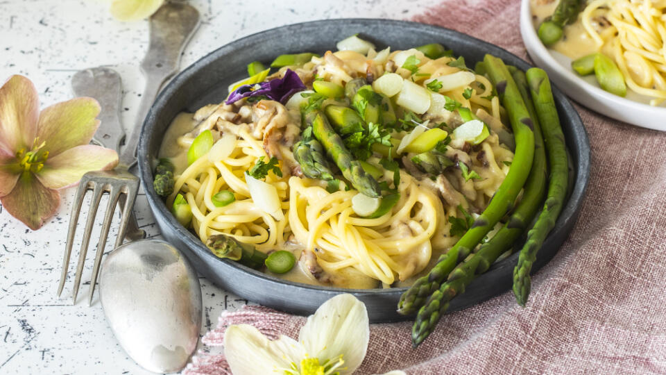 špargľové špagety carbonara

recept:
4 PORCIE, PRÍPRAVA 25 MINÚT, VARENIE 20 MINÚT
• 1 viazanička zelenej alebo aj bielej špargle • 500 g cestovín (ideálne pripravené tradičnou metódou „trafilata al bronzo“) • 200-300 g chudšej slaniny • 1-2 strúčiky cesnaku • 6 žĺtkov • 100 g parmezánu • soľ, mleté čierne korenie • olivový olej • zelený šalát
Na zálievku:
• 2-3 lyžice citrónovej šťavy • 1 lyžička horčice • 6 lyžíc olivového oleja
• 1 strúčik cesnaku (nemusí 