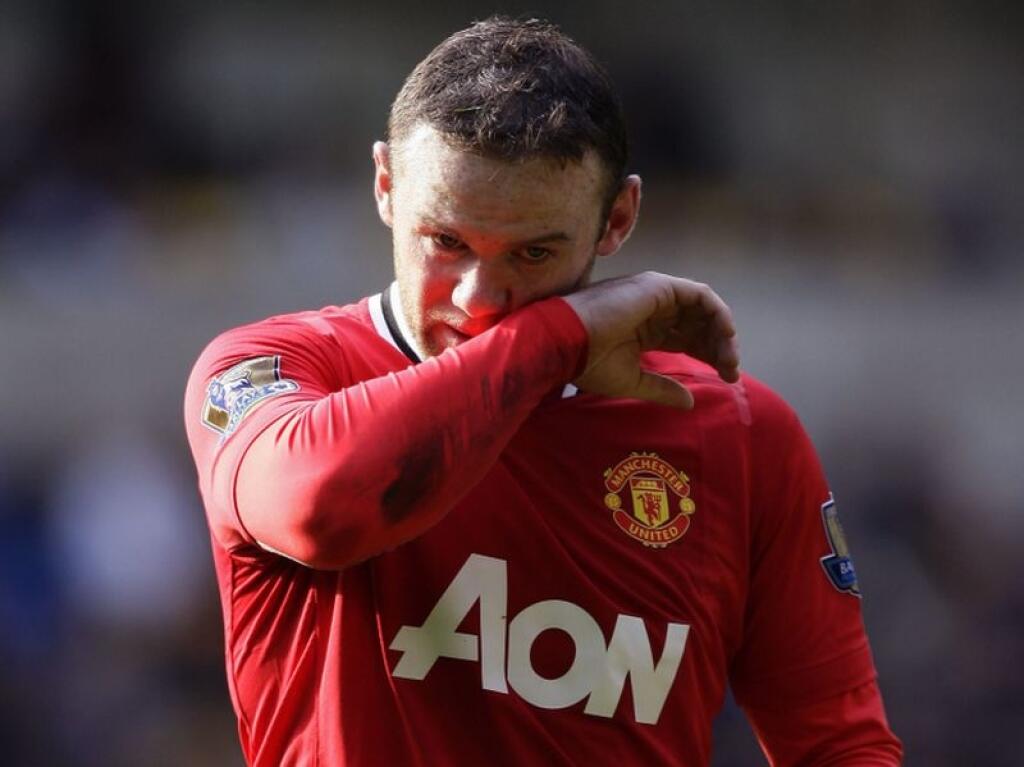 Manchester United's Wayne Rooney wipes his face during his team's 5-0 win over Wolverhampton Wanderers in their English Premier League soccer match at Molineux Stadium, Wolverhampton, England, Sunday, March 18, 2012. (AP Photo/Jon Super)
