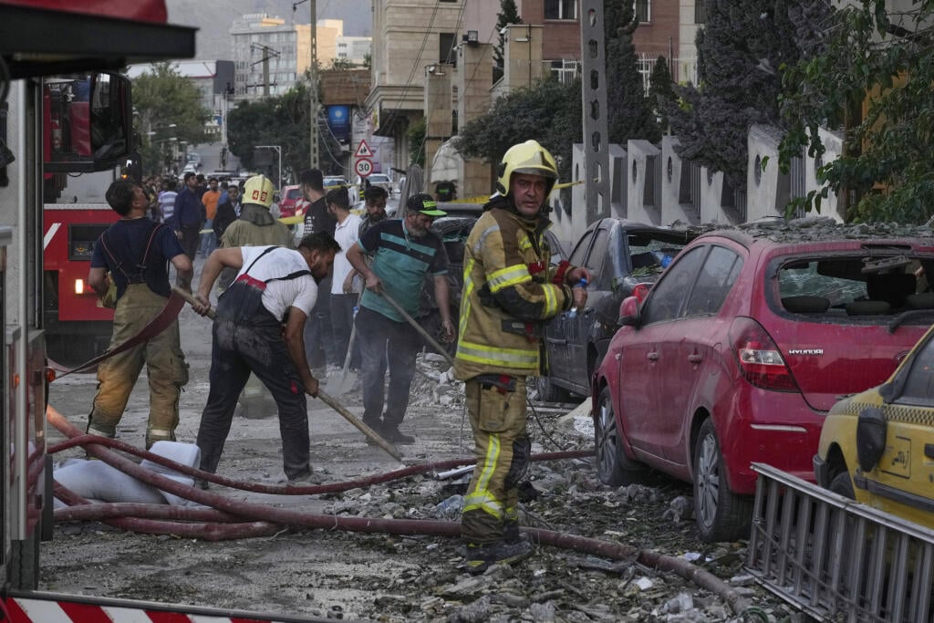 WA 7 Teherán - Na snímke hasiči a ľudia odstraňujú materiálne škody po útoku izraelskej armády na obytnú štvrť v iránskej metropole Teherán v piatok 13. júna 2025. Explózie v piatok otriasli iránskou metropolou Teherán a Izrael bezprostredne po tom oznámil, že na Irán uskutočnil „preventívny“ útok. Izraelský minister obrany Jisrael Katz následne vo svojej krajine vyhlásil výnimočný stav, informuje TASR podľa agentúr AP a DPA. FOTO TASR/AP 

Firefighters and people clean up the scene of an explos