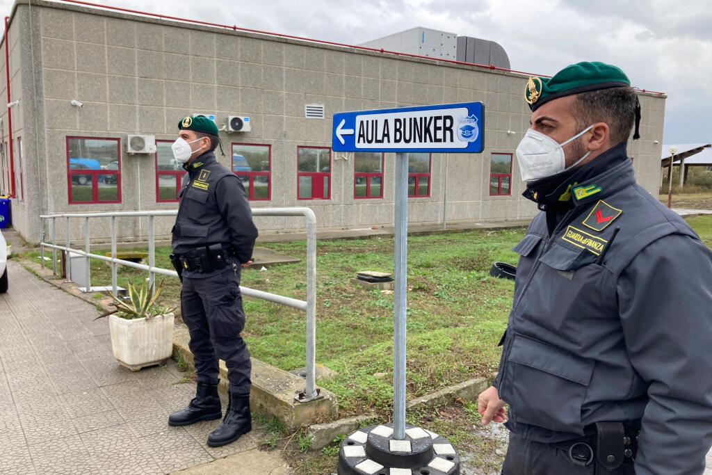 Talianski finanční policajti s ochrannými rúškami hliadkujú pred provizórnym súdom počas otvorenia procesu s 355 členmi kalábrijskej mafie 'Ndrangheta obvinenými z rôznych trestných činov vrátane vraždy, pokusu o vraždu, vydierania, prania špinavých peňazí a obchodovania s drogami v kalábrijskom meste Lamezia Terme, na juhu Talianska 13. januára 2021. Ide o najväčší súdny proces s mafiou v Taliansku za posledných viac ako 30 rokov.