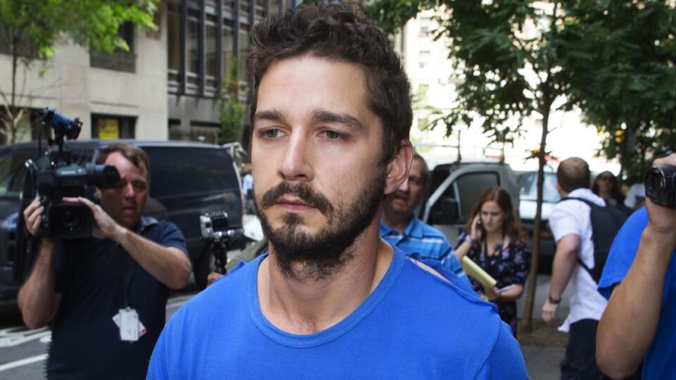 Actor Shia LaBeouf walks through the media after leaving Midtown Community Court following his arrest the previous day for yelling obscenities at a Broadway performance of "Cabaret", Friday, June 27, 2014, in New York. The 28-year-old, who starred in the first three "Transformers" movies, was arrested on charges of disorderly conduct and criminal trespass. He's due back in court July 24.  (AP Photo/John Minchillo)