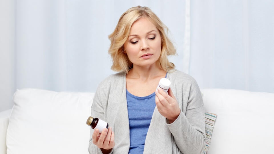 Woman,With,Medicine,Jars,At,Home