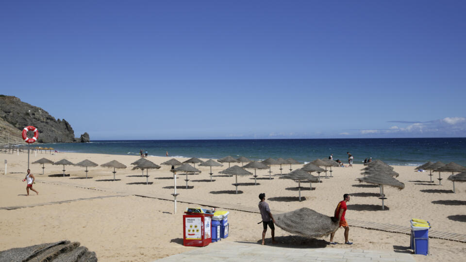 KK19 Praia da Luz - Muži rozkladajú slnečníky na pláži v portugalskom Praia da Luz 4. júna 2020. Prokuratúra v nemeckom meste Braunschweig vo štvrtok uviedla, že Madeleine McCannová, ktorá v máji 2007 ako trojročná za záhadných okolností zmizla počas pobytu s rodinou v portugalskom regióne Algarve, už pravdepodobne nie je nažive. Na otázky novinárov neodpovedal s tým, že v priebehu vyšetrovania nebudú o prípade poskytované ďalšie podrobnosti. Nemecká polícia v stredu oznámila, že v prípade zmizn