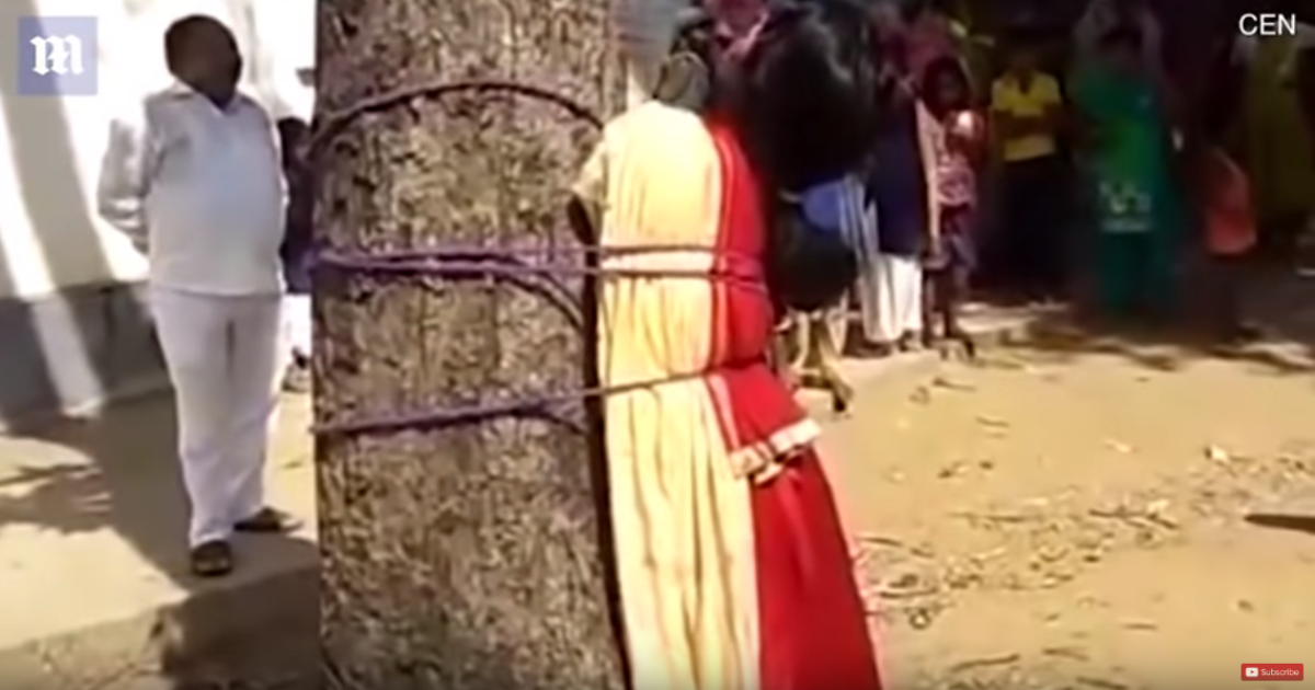 Привязанная к столбу девочка. Человек привязанный к дереву. Женщина привязанняк столбу.