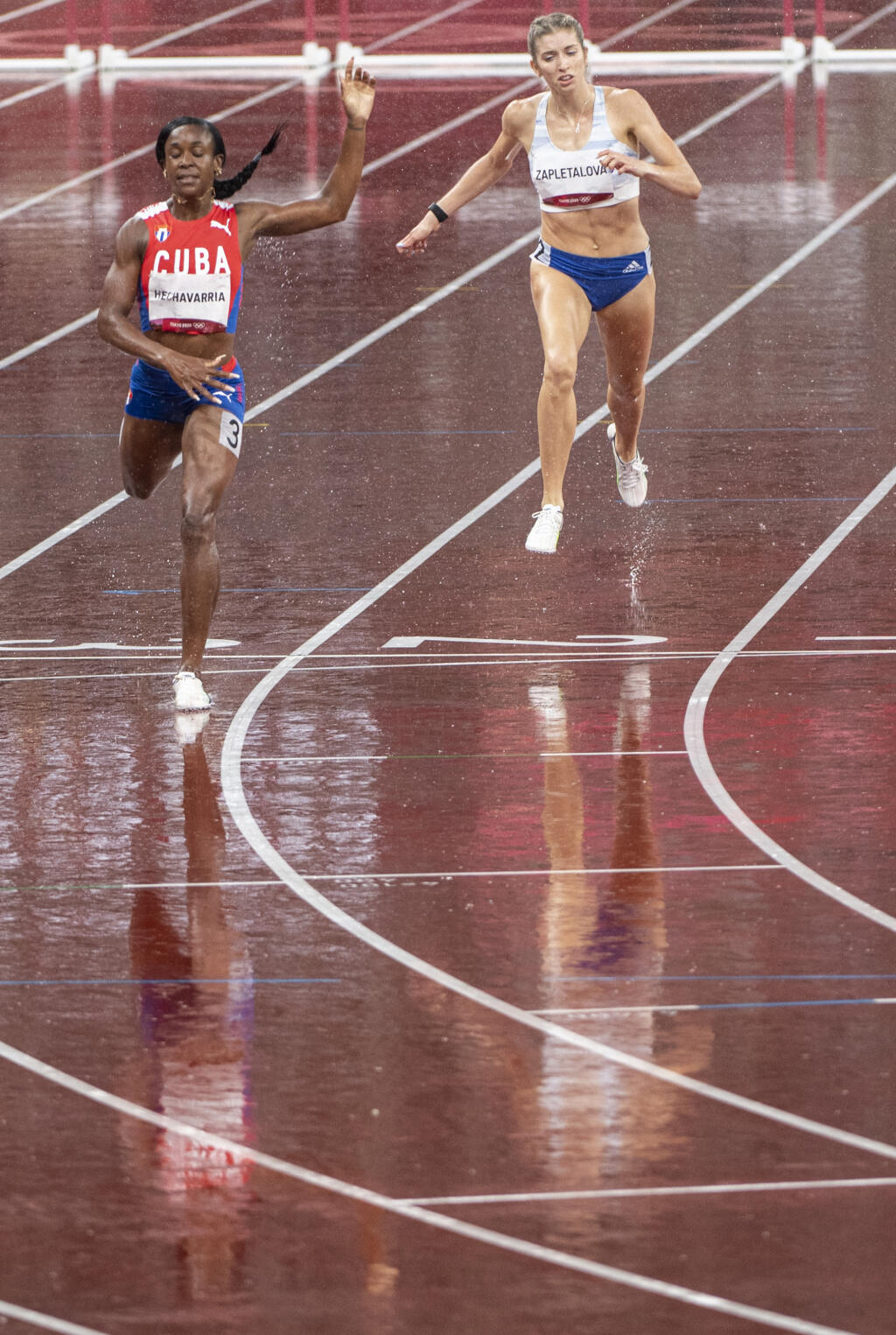 Na snímke vpravo slovenská atlétka Emma Zapletalová počas semifinále behu na 400 m prekážok na XXXII. letných olympijských hrách v Tokiu v pondelok 2. augusta 2021.