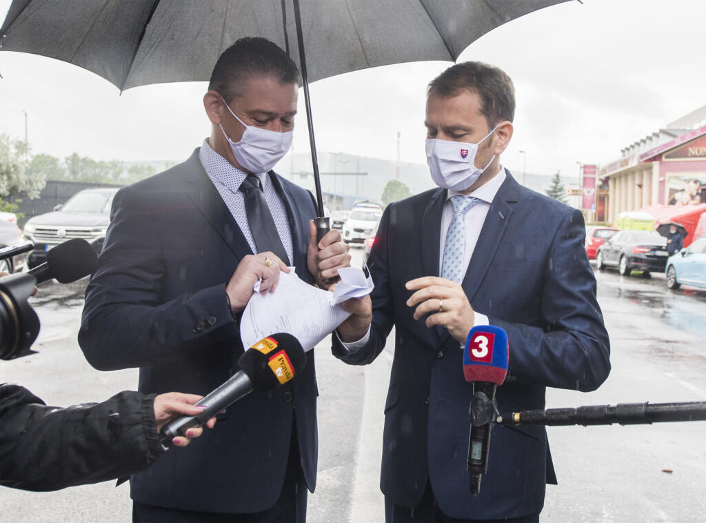 Na snímke vpravo predseda vlády SR Igor Matovič a vľavo minister vnútra SR Roman Mikulec symbolicky pretrhávajú formulár, ktorým sa občania SR museli preukázať pri vstupe do zahraničia a pri návrate do SR, 5. júna 2020 v Bratislave. FOTO TASR - Martin Baumann