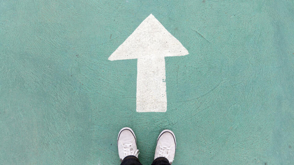 Shoes,Standing,On,The,Concrete,Floor,And,White,Direction,Sign