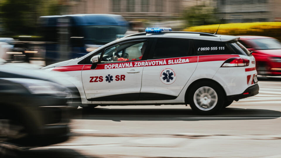 Vozidlo dopravnej zdravotnej služby so zapnutým výstražným svetlom prechádza križovatkou na Hodžovom námestí.
