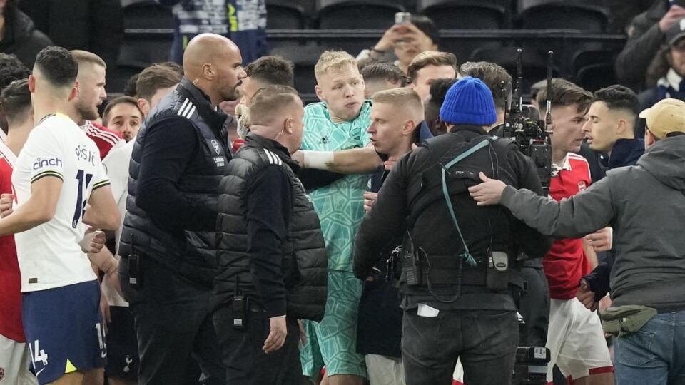 Bezprostredne po zápase vyliezol šialený fanúšik Tottenhamu na zábradlie a brankára londýnskeho Arsenalu Ramsdala (v zelenom) chcel kopnúť do chrbta.