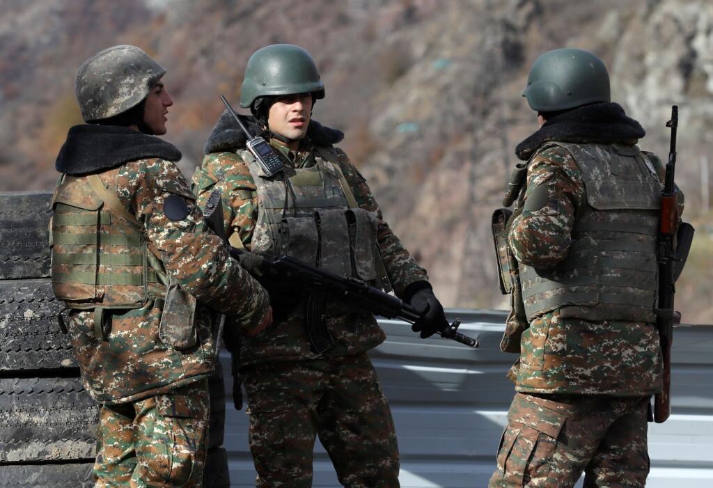 Etnickí arménski militanti stoja na kontrolnom stanovišti pri dedine Čarektar na hranici s azerbajdžanským okresom Kalbadžar, v samozvanom regióne Náhorný Karabach 25. novembra 2020. V spornej oblasti Náhorného Karabachu sa 7. septembra obnovili boje medzi Azerbajdžanom a Arménskom