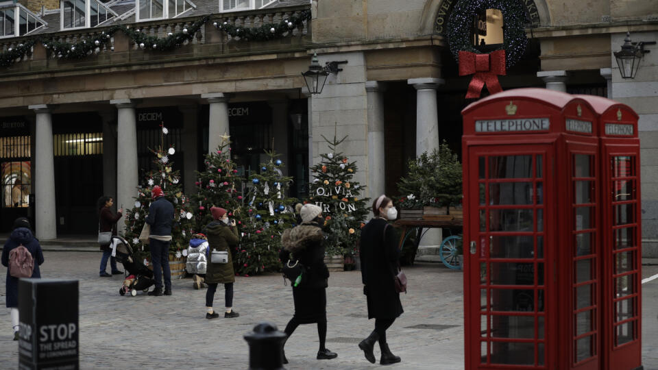 JB 19 Londýn - Ľudia s ochrannými rúškami kráčajú okolo vianočných stromčekov počas druhého lockdownu na ulici Covent Garden v Londýne 26. novembra 2020. Čiastočný lockdown na území Anglicka sa skončí 2. decembra, oznámil v pondelok britský premiér Boris Johnson. Čiastočný lockdown s rozsiahlymi obmedzeniami týkajúcimi sa najmä spoločenských aktivít platí v Anglicku od 5. novembra. Ľudia sa po jeho skončení budú môcť stretávať na otvorených priestranstvách v maximálnom počte šesť osôb a otvorené