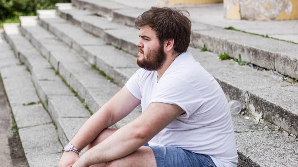 A,Guy,With,Brown,Hair,And,A,Beard.,He,Sits