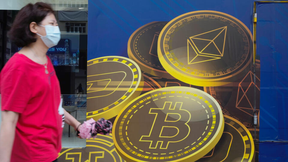 WA 11 archív Hongkong - Na archívnej snímke 1. júna 2021 žena kráča okolo reklamného plagátu najväčšej kryptomeny v Hongkongu. Po tom, ako v prvý deň týždňa klesla cena bitcoinu o viac než 10 %, pokračovala vo výraznom poklese aj v utorok 22. júna 2021. Tempo poklesu sa síce mierne spomalilo, cena najväčšej kryptomeny však klesla pod 30.000 USD a dostala sa tak na 5-mesačné minimum. FOTO TASR/AP
FILE - In this June 1, 2021, file photo, a woman walks past an advertisement for the Bitcoin cryptoc