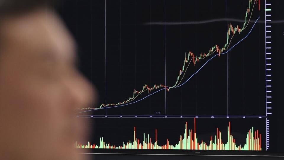 A man walks by a screen showing the price of bitcoin in Seoul, South Korea, Friday, Dec. 8, 2017. South Korean is studying ways to regulate speculative trading in crypto currencies as the latest surge in prices stokes a craze over bitcoins. (AP Photo/Lee Jin-man)