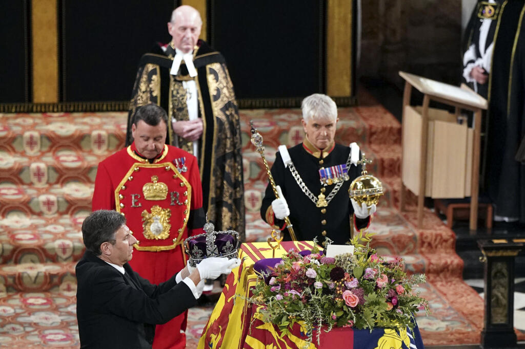 Na snímke královský klenotník berie kráľovskú korunu z rakvy s pozostatkami zosnulej britskej kráľovnej Alžbety II. počas obradu rozžehnania sa s telom v Kaplnke svätého Juraja na hrade Windsor v pondelok 19. septembra 2022.