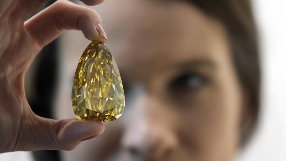 KK5 Dubaj - Špecialistka na šperky Sophie Stevensová drží diamant s názvom Golden Canary v galérii Sotheby's v Dubaji v pondelok 17. októbra 2022. Najväčší žltý bezchybný diamant na svete (303,10 karátov) sa bude dražiť v aukčnej sieni Sotheby's v New Yorku 7. decembra 2022 a jeho odhadovaná suma je okolo 15 miliónov dolárov (15,4 milióna eur). FOTO TASR/AP
Sotheby's jewellery specialist Sophie Stevens holds a Golden Canary polished diamond displayed at the Sotheby's Dubai gallery, Monday, Oct.