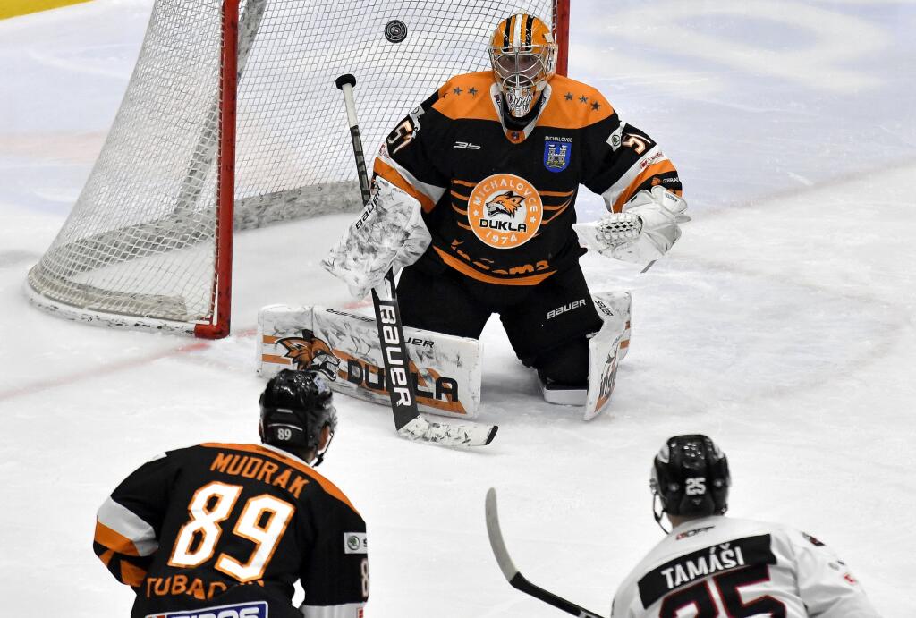 Na snímke zľava hráč HK Dukla Ingema Michalovce Dávid Mudrák a brankár Tomáš Tomek, vpravo hráč HC‘05 Banská Bystrica Alex Tamáši v zápase 41.kola hokejovej Tipos Extraligy HK Dukla Ingema Michalovce - HC‘05 Banská Bystrica 21. februára 2021 v Michalovciach. FOTO TASR – Roman Hanc