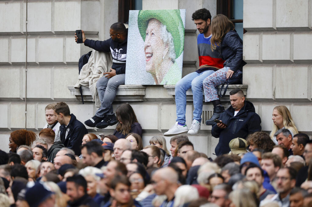 Ľudia čakajú na trase, po ktorej bude rakva zosnulej britskej kráľovnej Alžbety II. prevezená na delovom voze po pohrebnom obrade vo Westminsterskom opátstve.