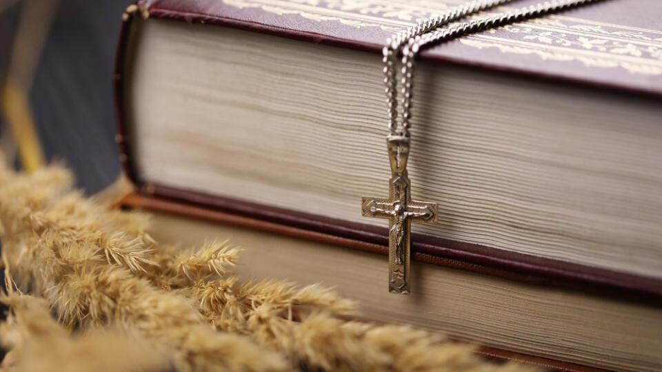 Silver,Necklace,With,Crucifix,Cross,On,Christian,Holy,Bible,Book