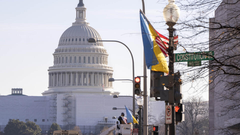 Pracovníci upevňujú americké a ukrajinské zástavy na Pennsylvania Avenue pri budove amerického Kapitolu pred návštevou ukrajinského prezidenta Volodymyra Zelenského v Bielom dome vo Washingtone 21. decembra 2022. Táto zahraničná cesta, jeho prvá od začiatku ruskej invázie na Ukrajinu, však závisí od bezpečnostnej situácie.