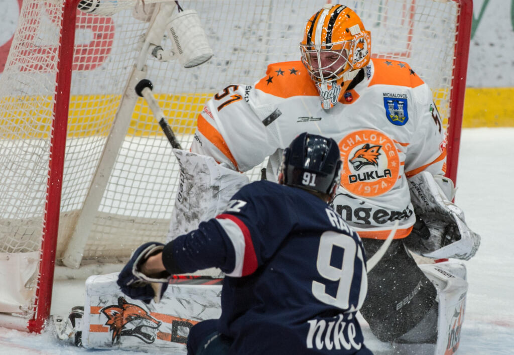 Na snímke v popredí Branislav Rapáč (Slovan) strieľa gól a v pozadí Tomáš Tomek (Michalovce) v predohrávke 40. kola hokejovej Tipos extraligy medzi HC Slovan Bratislava - HK Dukla Ingema Michalovce 18. februára 2021 v Bratislave. FOTO TASR - Martin Baumann