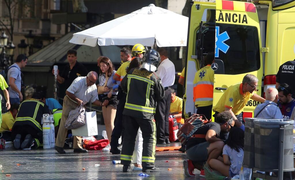 Záchranári ošetrujú zranených ľudí po teroristickom útoku autom na ulici La Rambla v Barcelone 17. augusta 2017. Do masy ľudí na hlavnej obchodnej a zábavnej ulici La Rambla v katalánskej metropole Barcelona dnes narazila svetlá dodávka. Polícia označila útok ako teroristický. Páchateľ z miesta ušiel. Podľa policajných informácii  sú najmenej trinásti mŕtvi a desiatky zranených, medzi nimi deti.