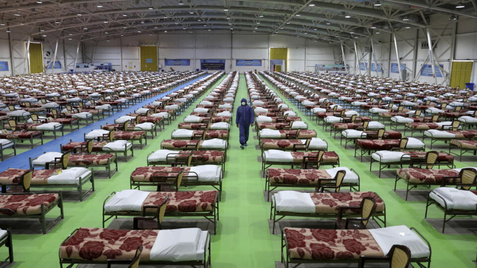 Na snímke člen iránskej armády kráča okolo postelí v dočasnej nemocnici s 2 000 lôžkami pre pacientov s koronavírusom COVID-19, ktorú zriadila armáda na medzinárodnom výstavisku v severnom Teheráne.